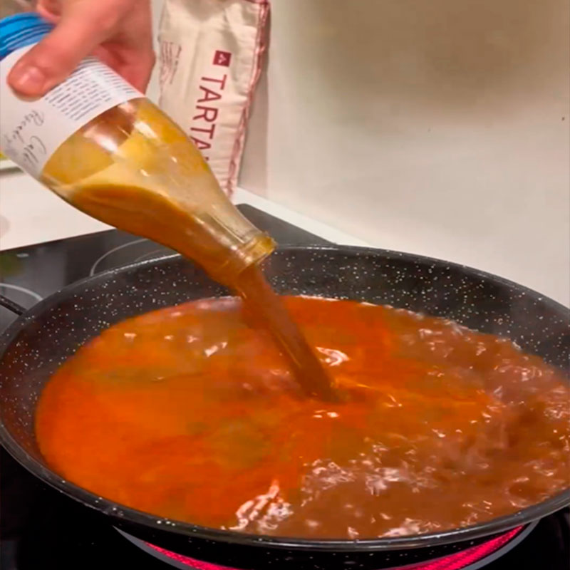 6.- Añade fumet, infusión de azafrán y jugo de gambas.